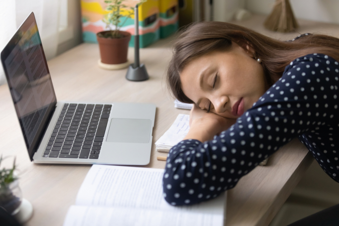 Ngủ gục trên bàn làm việc trong thời gian dài có thể làm biến dạng cột sống. Ảnh: Shutterstock