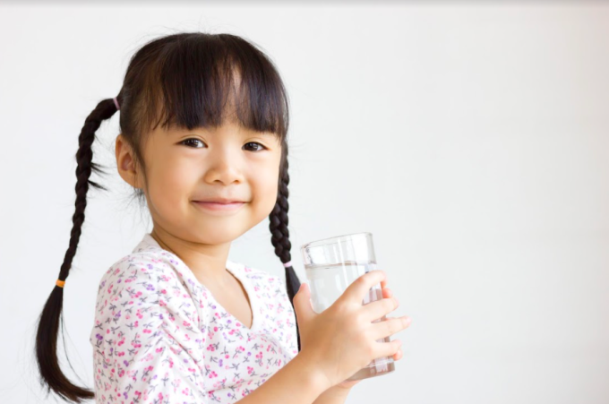 Cho trẻ uống ít nước trước khi ngủ là một trong những cách chữa đái dầm. Ảnh: Shutterstock