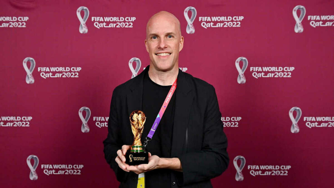 Nhà báo Grant Wahl cầm trên tay bản sao của chiếc cúp World Cup tại Trung tâm Truyền thông Chính ở Doha, Qatar, ngày 29/11. Ảnh: FIFA