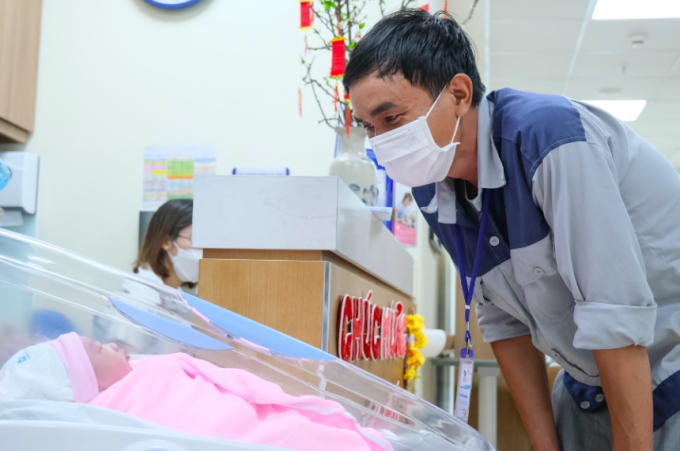 Niềm hạnh phúc của người cha lần đầu chạm mặt công chúa nhỏ. Ảnh: Nguyễn Dung.