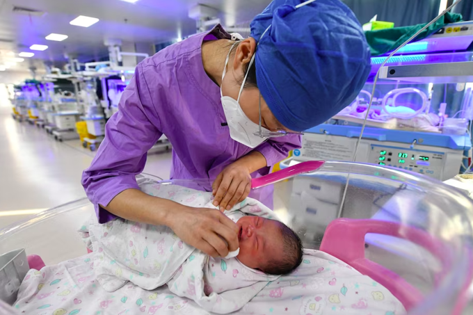 Một y tá đang chăm sóc trẻ sơ sinh tại bệnh viện thành phố Phụ Dương, Trung Quốc. Ảnh: AFP
