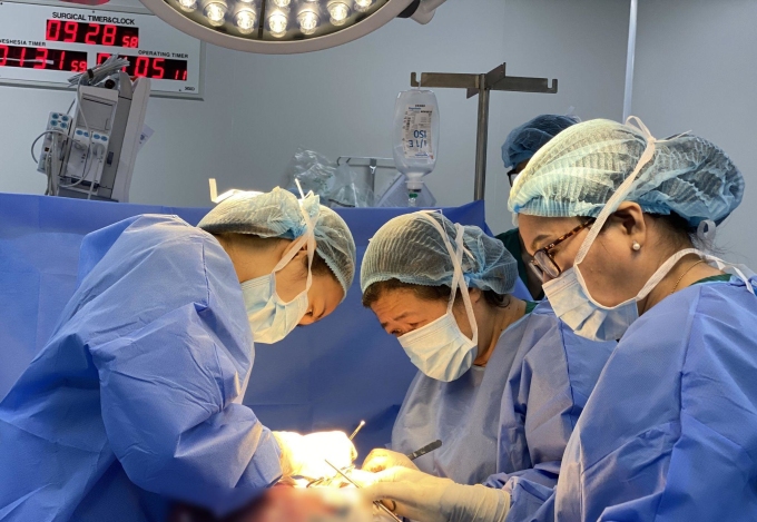 ThS.BS Trần Thị Thanh Thảo (ngoài cùng bên trái) đang cùng BS.CKII Nguyễn Bá Mỹ Nhi thực hiện ca mổ bóc tách u xơ tử cung cho người bệnh. Ảnh: Tuệ Diễm