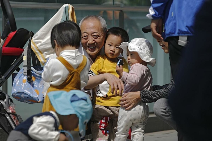 Một cụ ông chơi cùng các cháu của mình tại Bắc Kinh, tháng 5/2021. Ảnh: AP