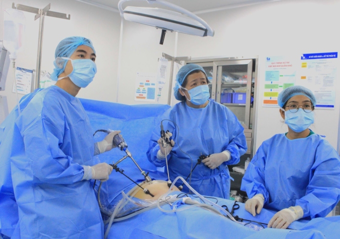 BS.CKII Nguyễn Bá Mỹ Nhi (giữa), BS.CKI Nguyễn Huy Cường (trái) phẫu thuật bóc u buồng trứng cho Ngân. Ảnh: Tuệ Diễm