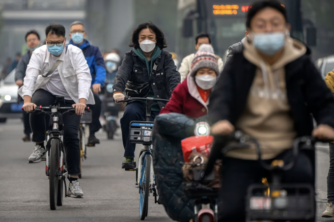 Người dân đeo khẩu trang khi đi lại trên đường phố Bắc Kinh, tháng 10/2022. Ảnh: AP