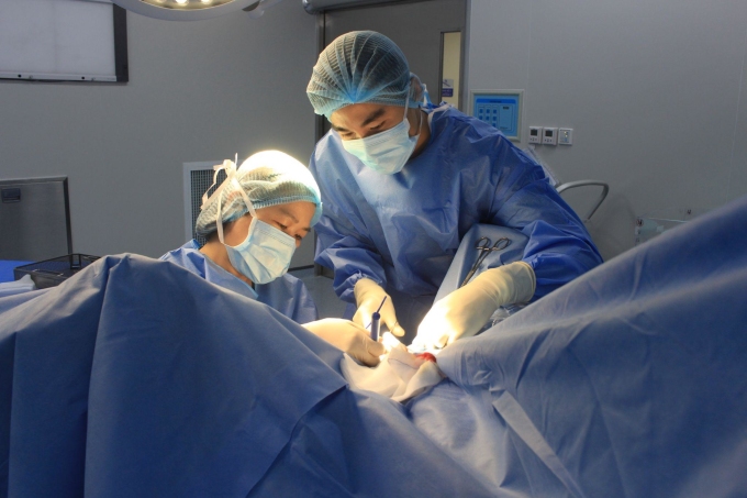 ThS.BS Nguyễn Thị Thanh Tâm (trái) thực hiện phẫu thuật tái tạo âm hộ cho chị Minh. Ảnh: Tuệ Diễm