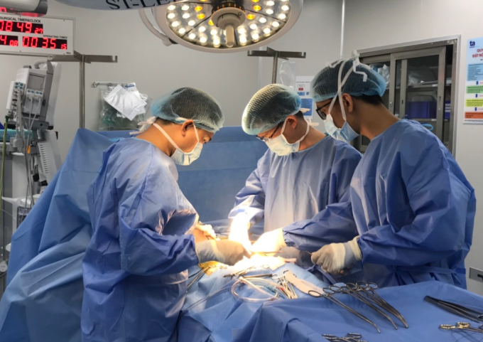 Bác sĩ Tấn (giữa) cùng êkíp phẫu thuật cắt tử cung cho người bệnh bằng phương pháp mổ hở với dao siêu âm Harmonic Scaple thế hệ mới nhất của Mỹ. Ảnh: Tuệ Diễm