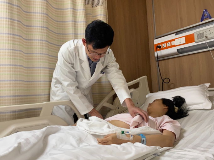 Bác sĩ Tấn kiểm tra vết mổ cho chị Thu trước khi xuất viện. Ảnh: Nguyễn Trăm
