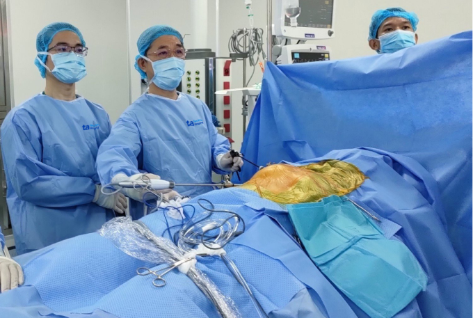 TS.BS Nguyễn Anh Dũng (bên phải) trong một ca phẫu thuật nội soi cho người bệnh. Ảnh: Quỳnh Châu