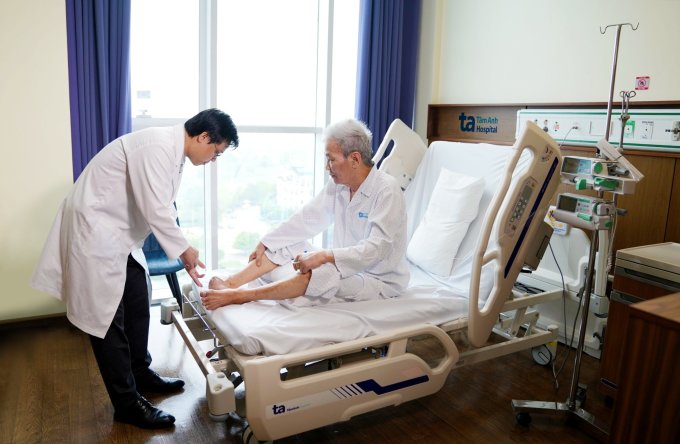 Tiến sĩ Bá Ngọc khám chân cho NSƯT Bằng Thái sau phẫu thuật. Ảnh: Bệnh viện Đa khoa Tâm Anh