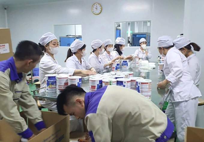 Công nhân đóng hộp thành phẩm sữa giả tại cơ sở sản xuất trong vụ công an phá hiện gần 500 loại sữa giả. Ảnh:CAND