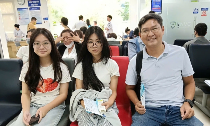 Anh Tuấn và hai con gái tại Trung tâm tiêm chủng VNVC Hoàng Văn Thụ, TP HCM. Ảnh: Hoàng Dương