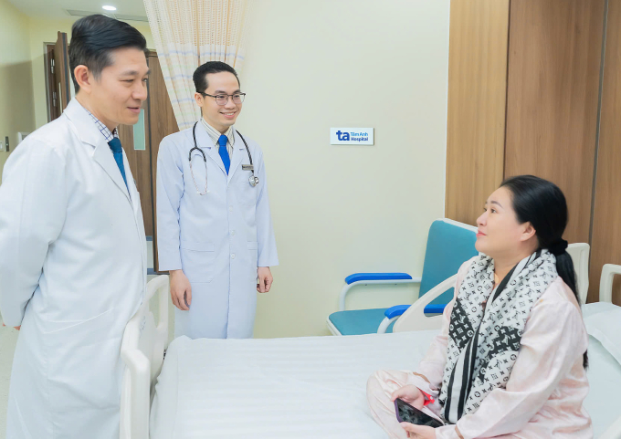 Bác sĩ Dũng (ngoài cùng bên trái) và bác sĩ Hoài hỏi thăm sức khỏe của bà Phượng sau hai ngày sau phẫu thuật. Ảnh: Thanh Luận